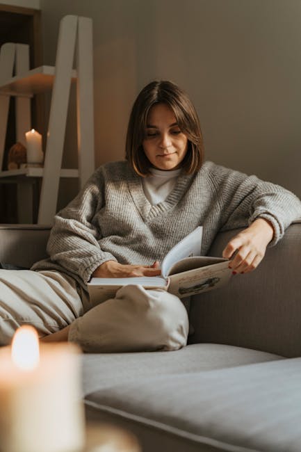 Woman in a cozy sweater reading a book on a comfortable sofa, creating a warm, serene atmosphere. phone-free morning routine