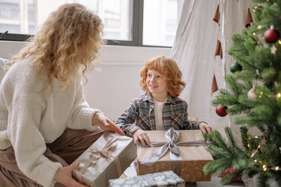 A joyous moment between mother and son unwrapping Christmas gifts by the decorated tree indoors.