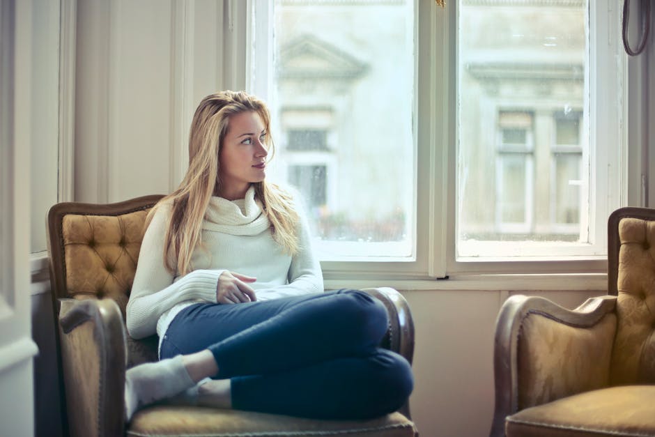 A serene moment of a woman doing nothing in a cozy room, enjoying leisure time by the window.